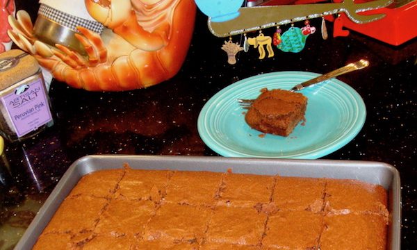 sheet pan of brownies and aqua plate with one brownie on countertop