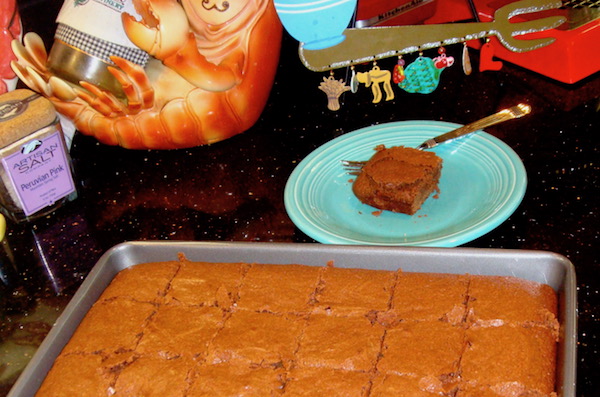 sheet pan of brownies and aqua plate with one brownie on countertop