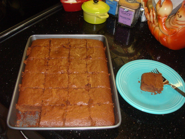 sheet pan filled with brownies with one brownie on aqua plate