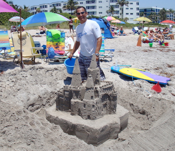 A man on the beach creating an intricate sand castle