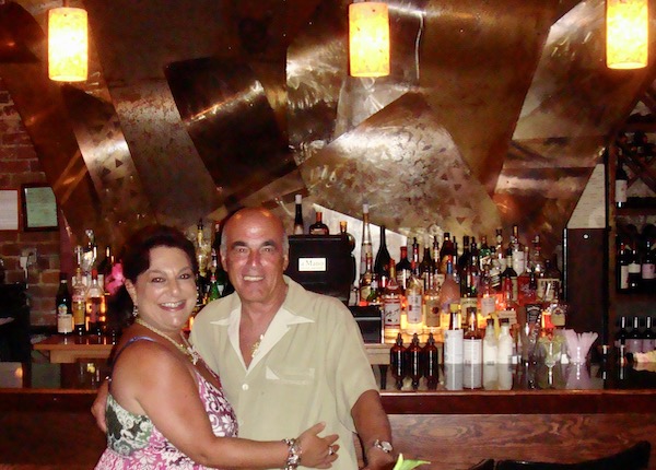 A man and a woman in front of a restaurant bar.
