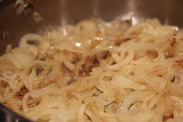 Large sauté pan filled with caramelizing onions