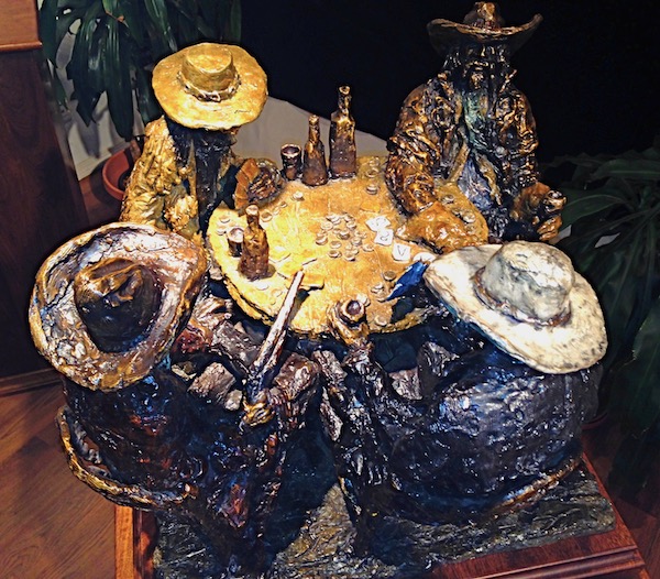 A painted bronze sculpture of five cowboys playing cards