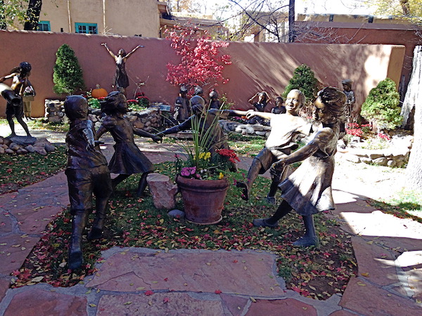 A shopping area with bronze sculptures of children playing