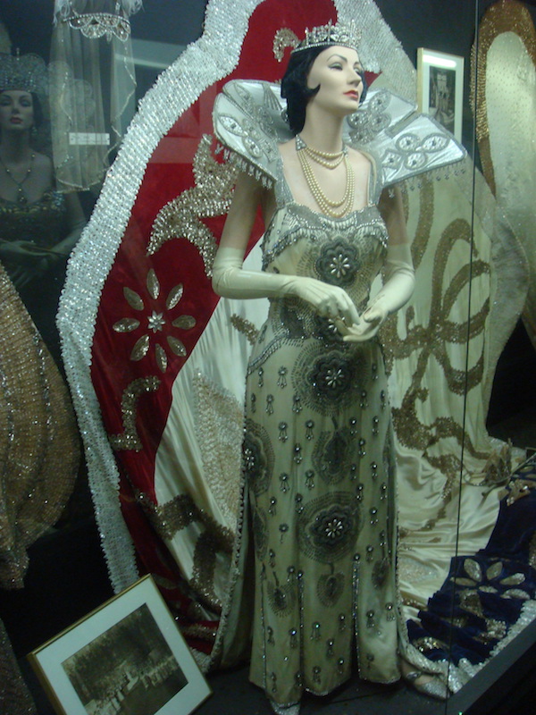 Female mannequin wearing an elaborate cream and gray lace gown