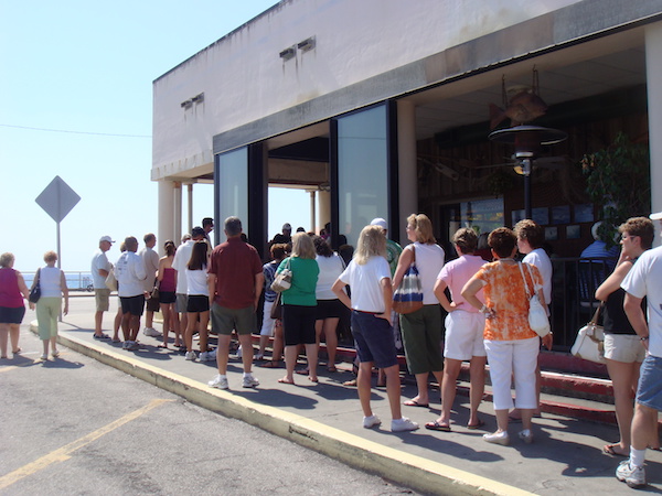 A long line of people waiting outside a restaurant