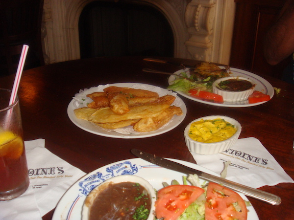 A wood table topped with several plates of food.