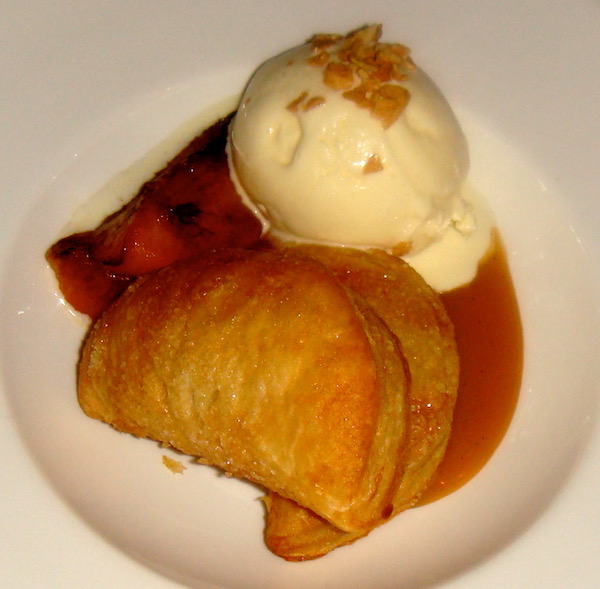 A white plate topped with Almond Turnovers Roasted Alabama Peaches and Sweet Corn Ice Cream