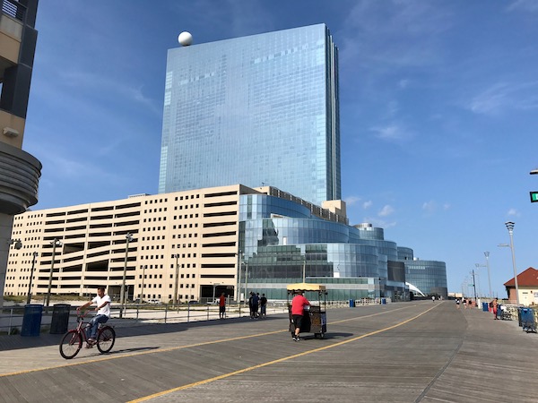 A large mirrored glass building seen from the boardwalk