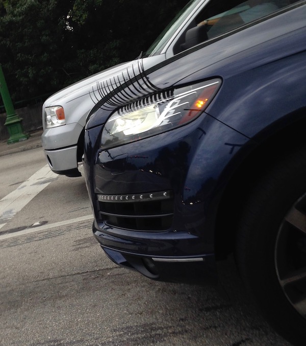 A dark blue SUV with long fake eyelashes on the headlights.