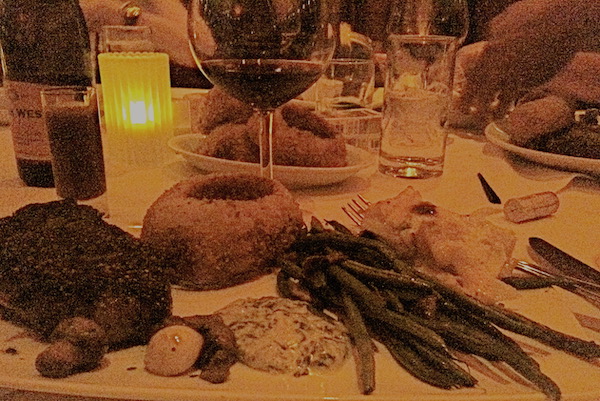 A large plate topped with filet mignon, and onion ring, and green beans.
