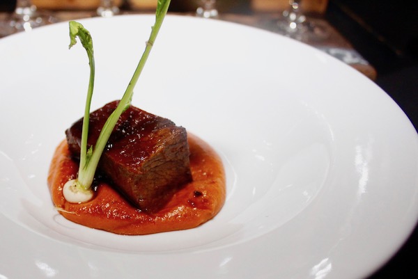 A white plate topped with Braised Short Rib + Three Chiles + Agave Demi + Potato-Guajillo Purée