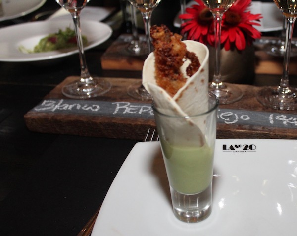 A tall slim shot glass filled with a tortilla and fried soft shelled crab
