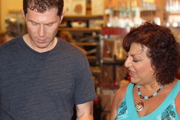 A man in a dark grey t-shirt and a woman in a turquoise tank top in a kitchen wares store