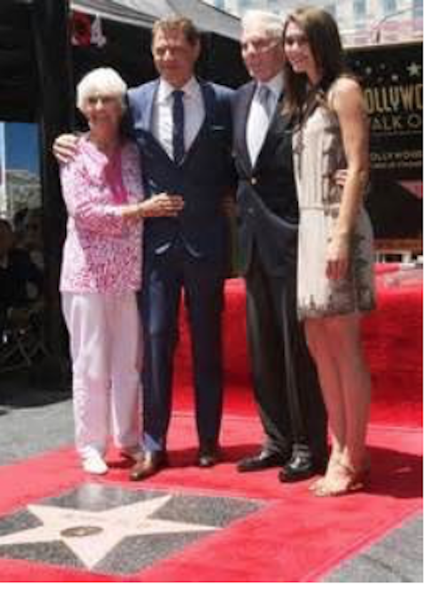 Two men and two women standing by a star at the Hollywood Walk of Fame