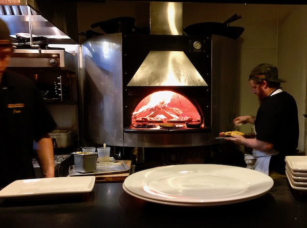 The kitchen of a restaurant with a Super Hot Wood Burning Oven