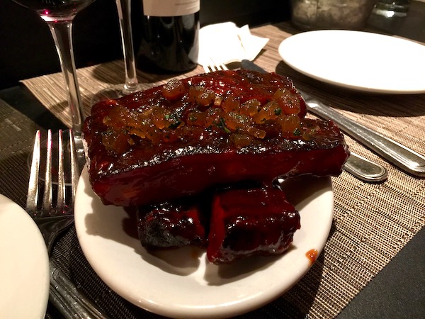 Smoked Pork Ribs with Watermelon Pickle overflowing on a white plate