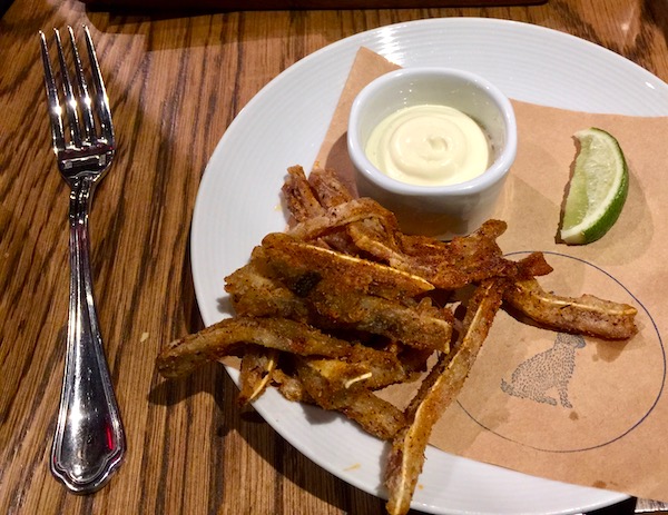 Spiced Pigs Ears with Smoked Aioli on brown paper on a white plate