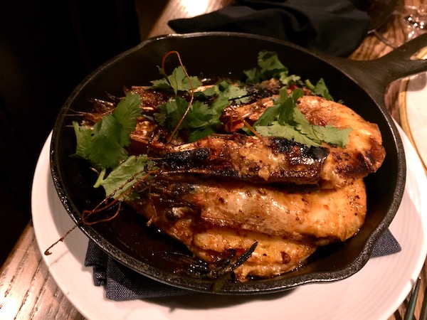 Broiled Shrimp with Calabrian Chile Butter in a small cast iron skillet sitting on a white plate