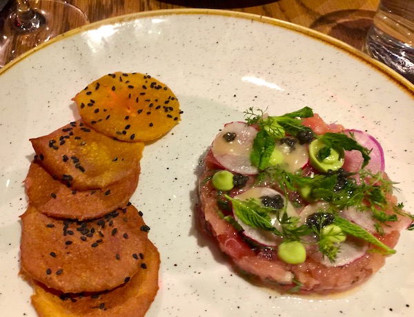 Smoked Tuna Tartare and sesame crackers on a white plate