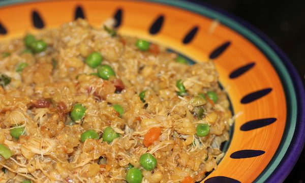 Bright yellow and dark blue rimmed pasta bowl filled with risotto, peas, pancetta and crabmeat.