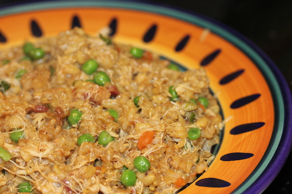 Bright yellow and dark blue rimmed pasta bowl filled with risotto, peas, pancetta and crabmeat.