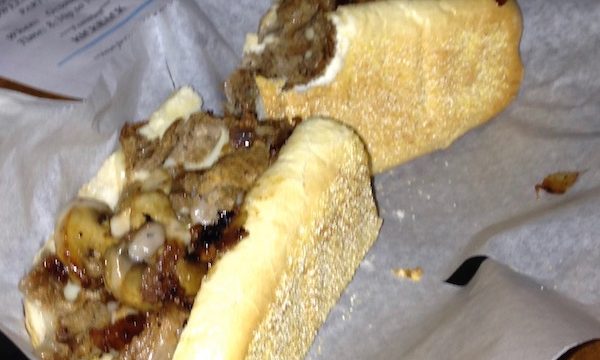 A cheesesteak on white deli paper