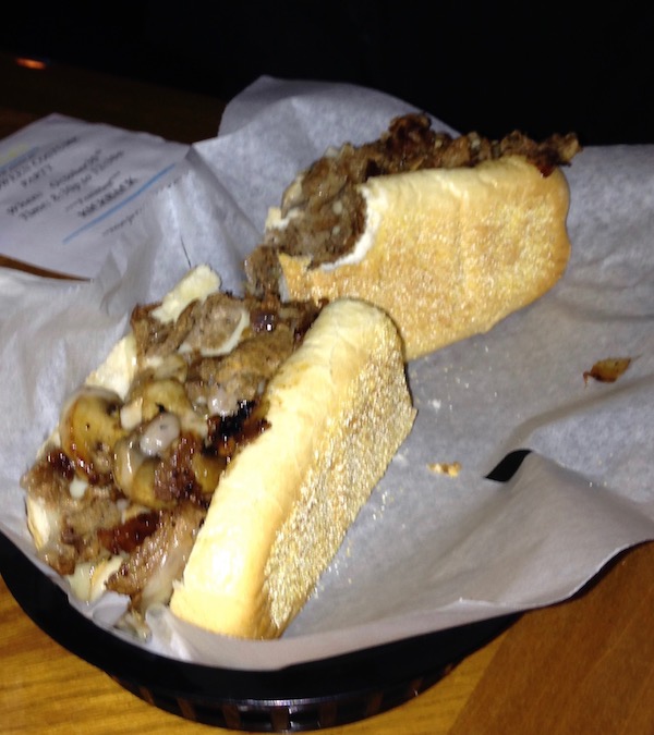 A cheesesteak on white deli paper