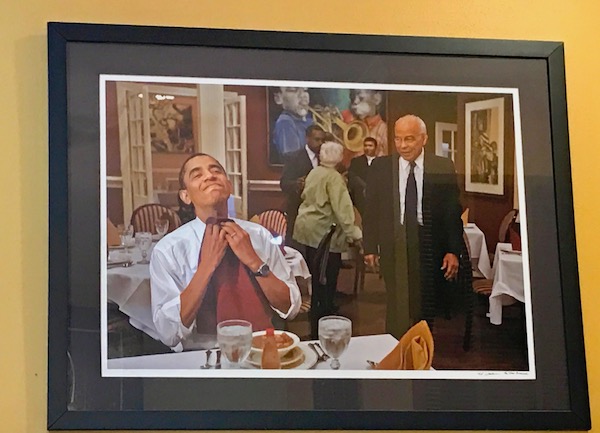 A framed photo of President Obama Getting Ready for his Meal by tucking a napkin into his shirt collar