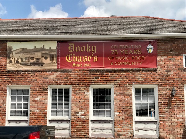A brick building with windows and doors and a banner that reads Dooky Chase's Restaurant