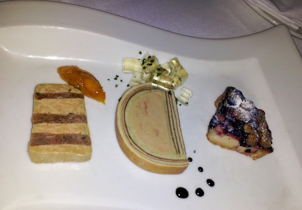 A wavy white plate topped with three different foie gras preparations