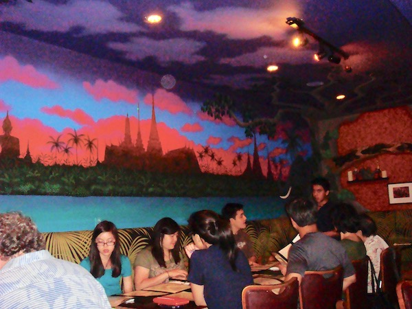 A restaurant with a mural of sky and coral clouds