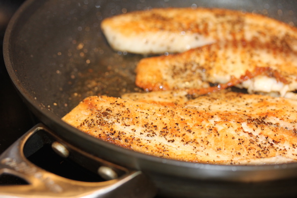Anodized pan with two perfectly cooked tilapia filets