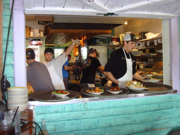 Several chefs working in a small kitchen