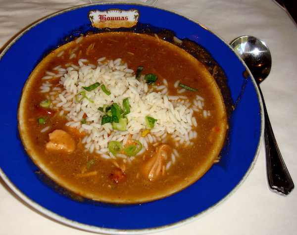 A cobalt blue rimmed soup bowl filled with chicken and andouille gumbo and rice.