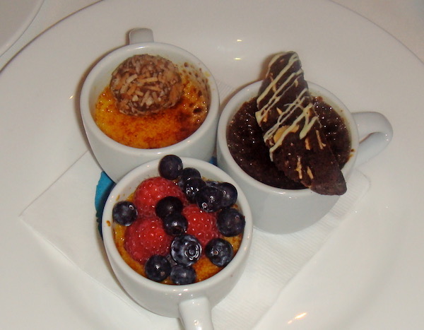 A trio of white coffee cups filled with three different creme brûlées