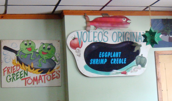 Pale green walls of a restaurant with the sign Voleo's Original