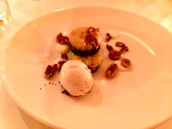Chocolate Cake with house made Strawberry Ice Cream and Toasted Pecans on a white plate