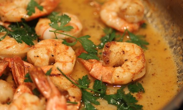 Cooked shrimp in tan sauce with parsley
