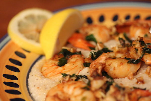 Yellow and blue rimmed pasta bowl with shrimp, lemon wedge and grits