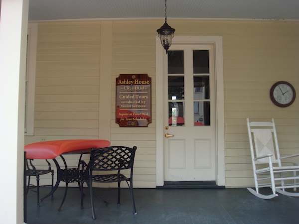 A small cottage with a porch and rocking chair.
