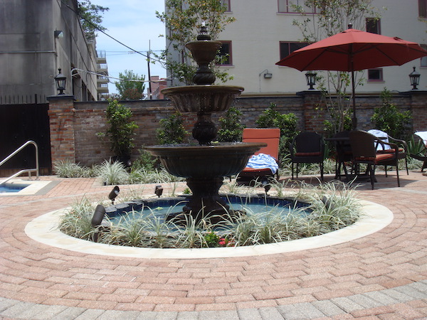 A beautiful round tiered fountain on a pavered patio.