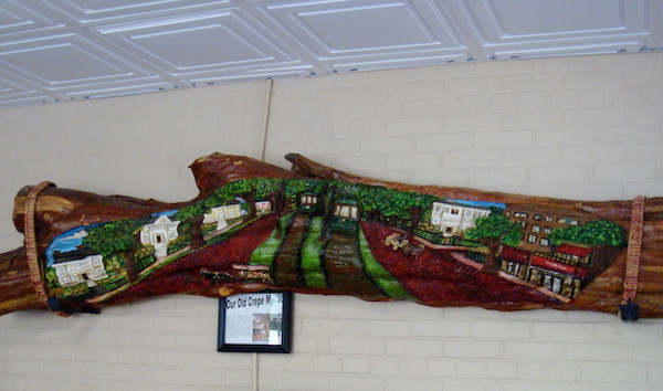 A crepe myrtle branch painted with a view of St. Charles Street New Orleans