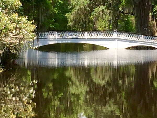 A beautiful white bridge spanning a lake surrounded by trees