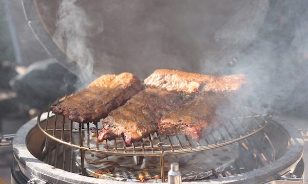 Ribs smoking with lots of smoke in a Kamado grill