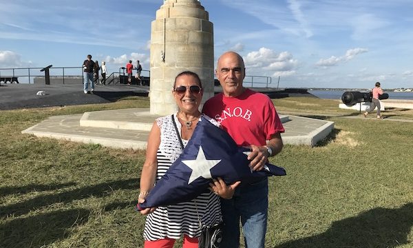 A man and a woman holding a folded American flag