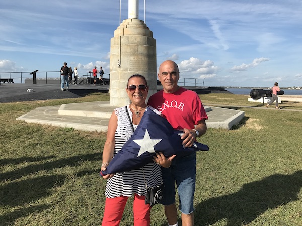 A man and a woman holding a folded American flag