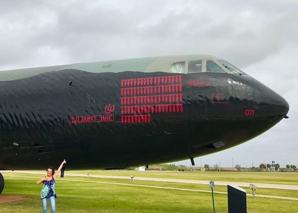 The front of an old military plane with red bombs painted in rows