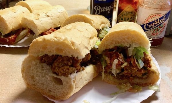 Two plates filled with po' boy sandwiches