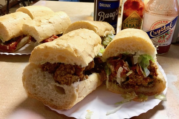 Two plates filled with po' boy sandwiches